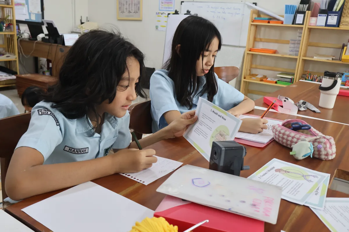 Elementary students engaged in research, writing, and collaborative learning at Pascal Montessori