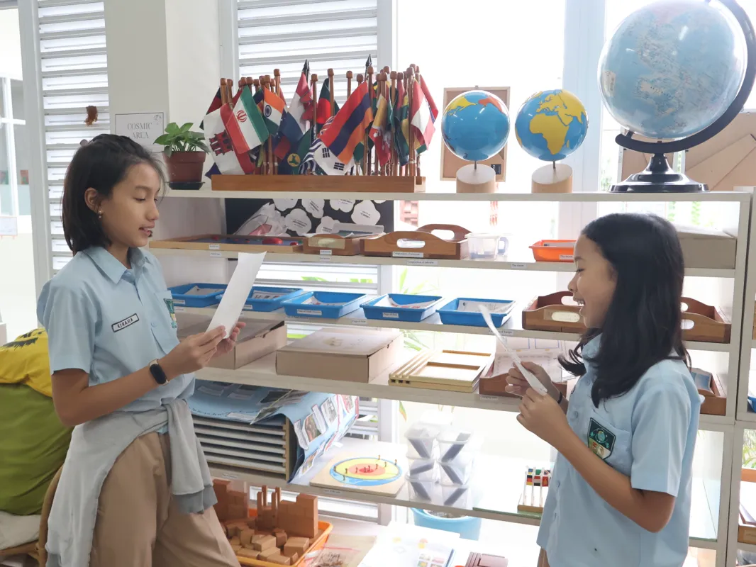 A Pascal Montessori educator providing thoughtful guidance to a child